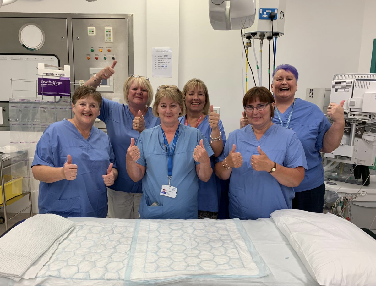 A scrub team in a maternity theatre with their thumbs up