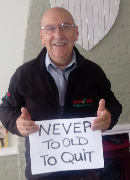 A person holding a card that says 'Never too old to quit'